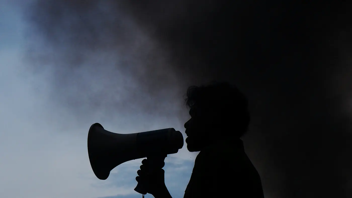 Whistleblowing – odvaha oznamovatele upozornit na problém, symbolizovaná siluetou s megafonem
